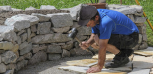 landscaper laying down informal patio stone